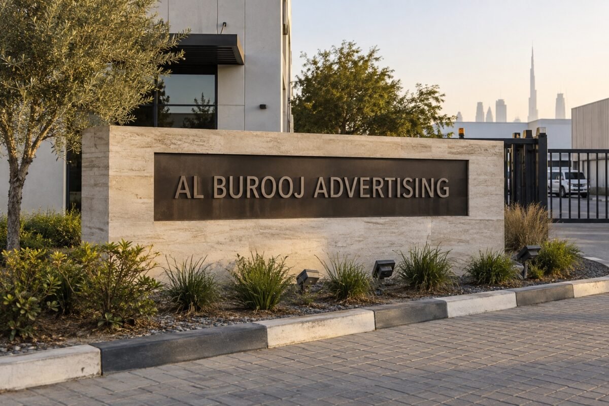 illustrative low stone-clad monument sign bearing al burooj advertising lettering