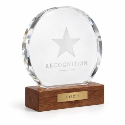 Round clear crystal award mounted on wood base, studio illustration