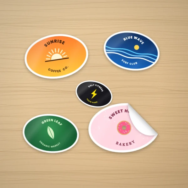 Custom oval stickers with logos on a wooden desk